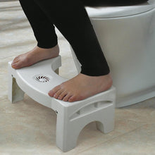 Space-saving folding toilet stool in white, with non-slip grip.